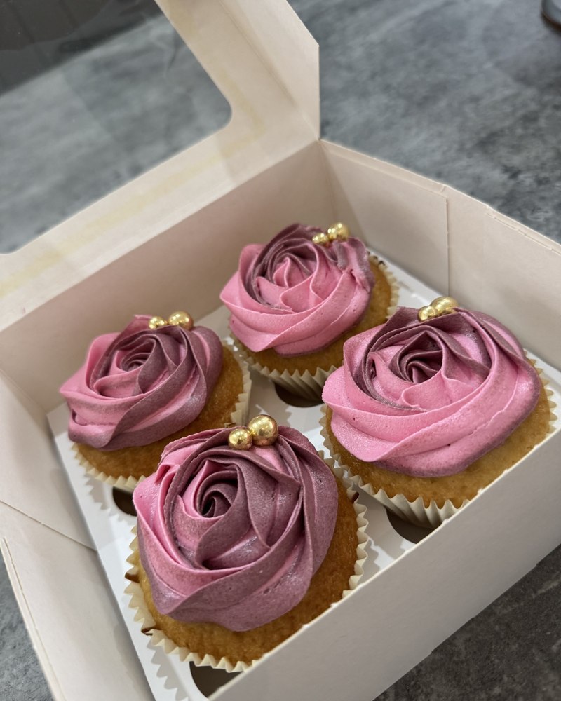 Cupcakes with mauve-pink buttercream roses and gold pearls