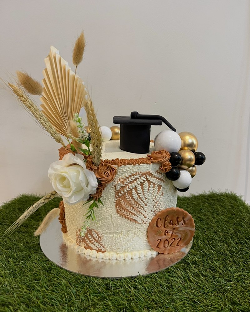 Class of 2022 graduation cake with dried florals and gold balloons